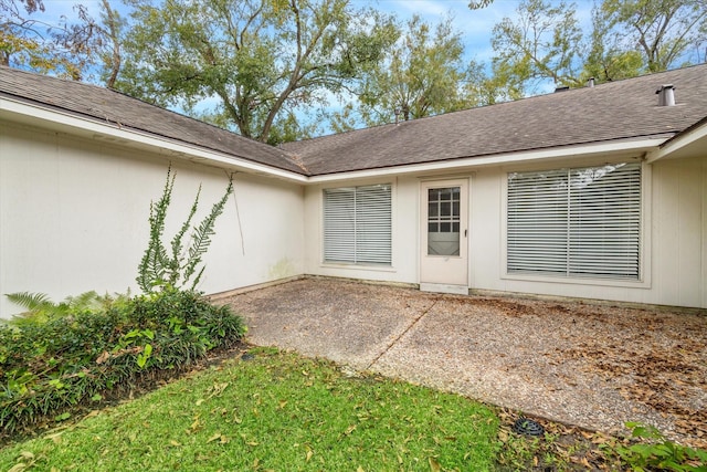 view of exterior entry with a patio area