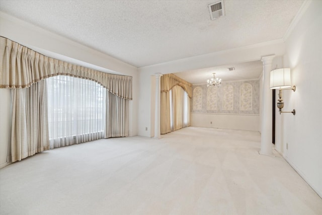 empty room featuring a textured ceiling, an inviting chandelier, crown molding, and carpet flooring