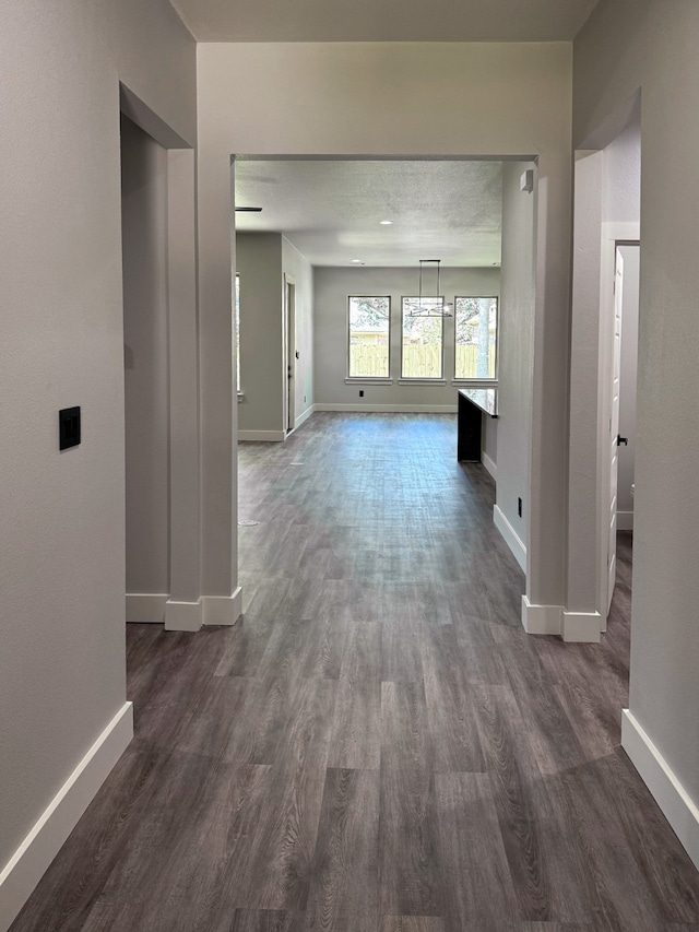 hallway with dark hardwood / wood-style floors and a textured ceiling