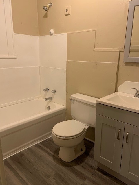 full bathroom featuring tub / shower combination, hardwood / wood-style flooring, vanity, and toilet