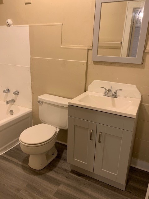 full bathroom featuring wood-type flooring, vanity, toilet, and shower / bath combination