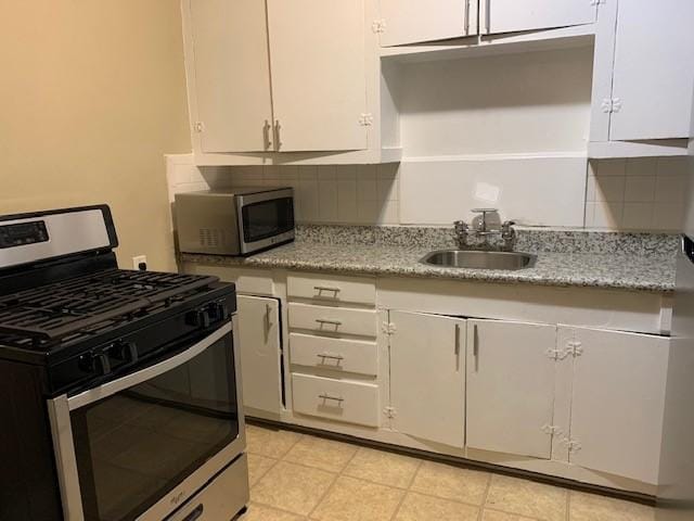 3205 Illinois St, Baytown, TX 77520 - kitchen featuring stainless steel appliances, white cabinets, tasteful backsplash, and light stone countertops