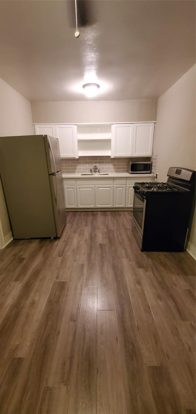 3205 Illinois St, Baytown, TX 77520 - kitchen featuring stainless steel appliances, white cabinets, dark wood-type flooring, and tasteful backsplash