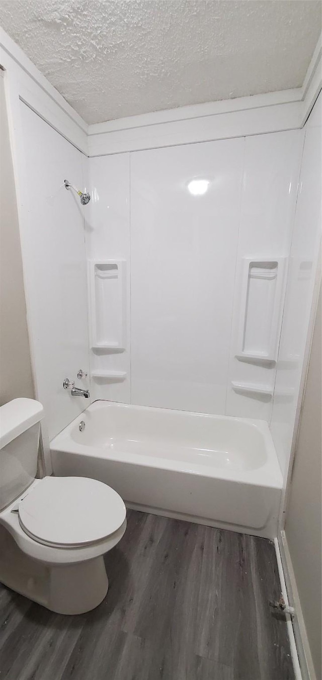 3205 Illinois St, Baytown, TX 77520 - bathroom featuring wood finished floors, tub / shower combination, and a textured ceiling