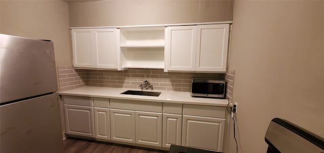 kitchen with white cabinetry, sink, dark hardwood / wood-style flooring, and white fridge