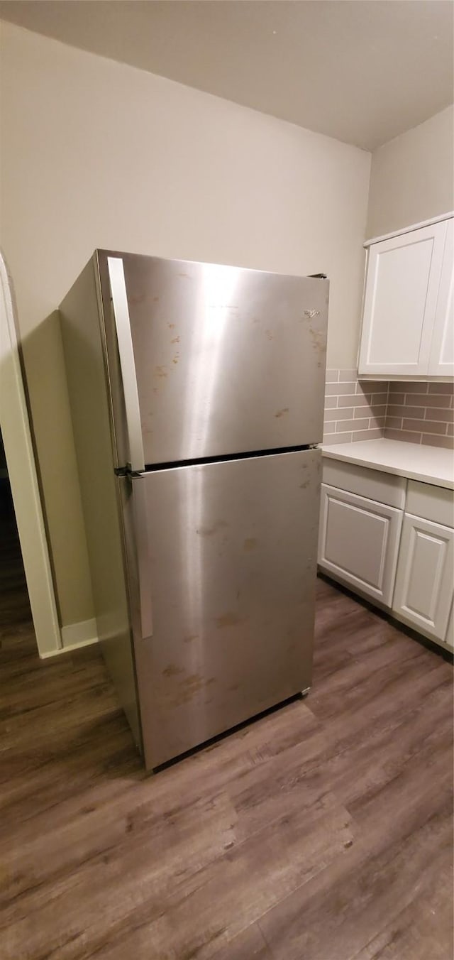 3205 Illinois St, Baytown, TX 77520 - kitchen with freestanding refrigerator, white cabinetry, dark wood-style flooring, light countertops, and backsplash