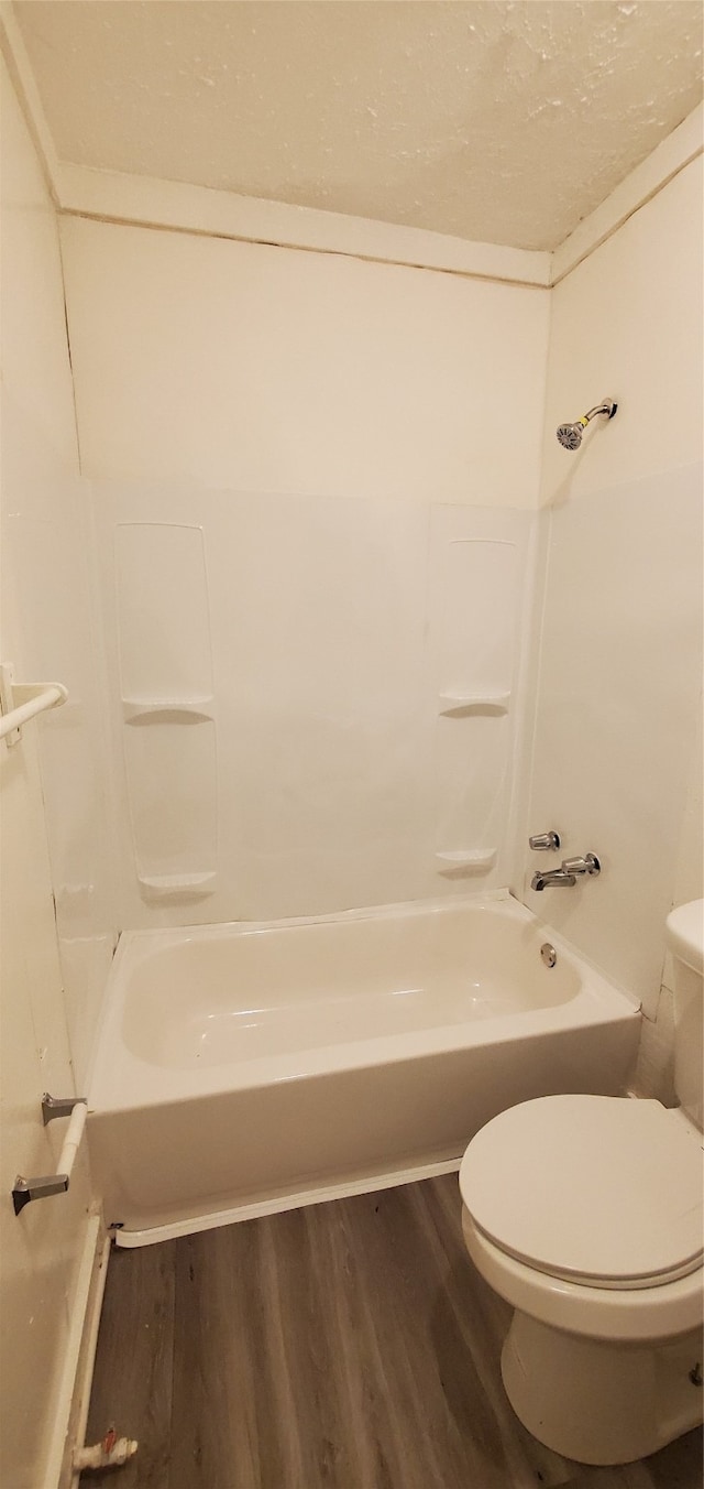 bathroom featuring hardwood / wood-style floors, toilet, and  shower combination