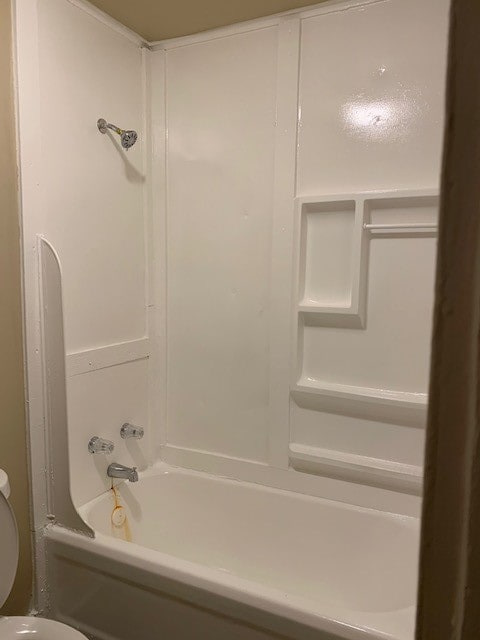 bathroom with tub / shower combination and toilet