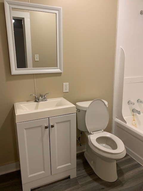 full bathroom featuring hardwood / wood-style flooring, vanity, and toilet