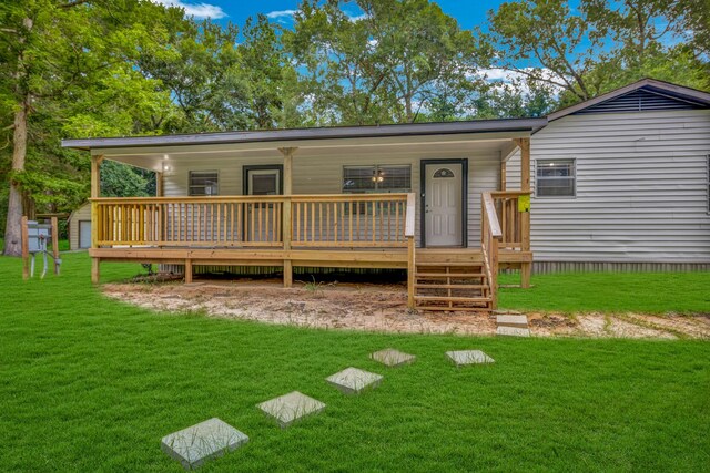 view of front of property with a garage, a wooden deck, and a front lawn