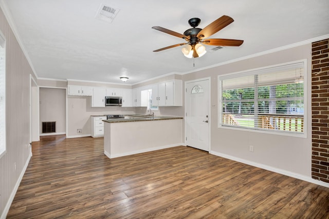 kitchen featuring white cabinetry, ornamental molding, kitchen peninsula, and appliances with stainless steel finishes