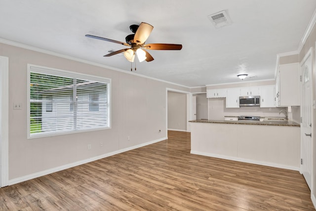 unfurnished living room featuring sink, ornamental molding, and light hardwood / wood-style floors