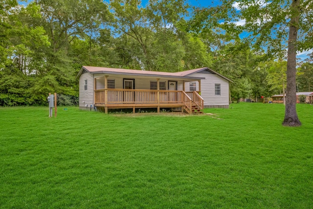 rear view of property featuring a wooden deck and a lawn