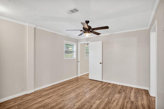 spare room featuring hardwood / wood-style floors, crown molding, and ceiling fan