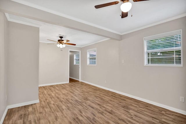 spare room with crown molding, plenty of natural light, ceiling fan, and hardwood / wood-style flooring