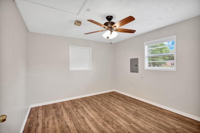 unfurnished room with ceiling fan, electric panel, and hardwood / wood-style floors