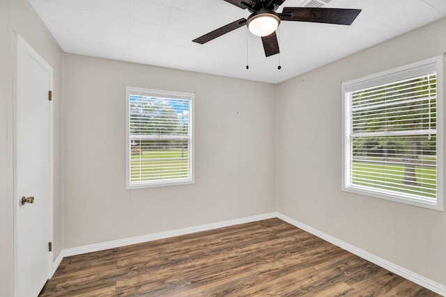 empty room with ceiling fan and dark hardwood / wood-style flooring