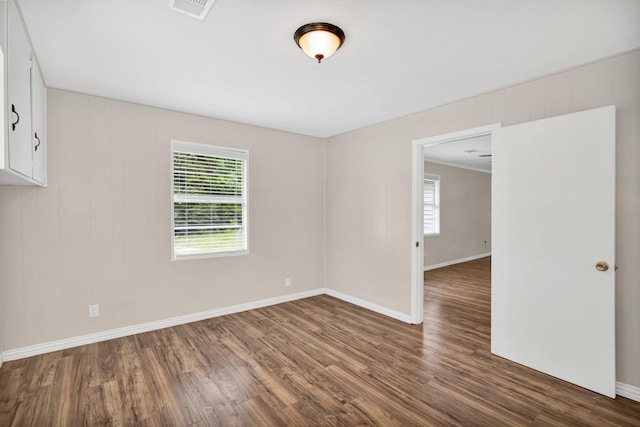 empty room featuring dark wood-type flooring and a wealth of natural light