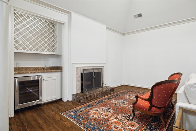 living room with dark hardwood / wood-style floors, a tiled fireplace, and beverage cooler