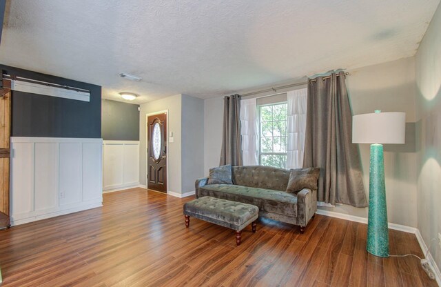 living room featuring wood-type flooring and a textured ceiling