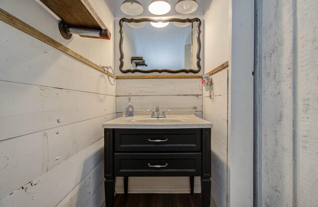 bathroom with wooden walls and vanity