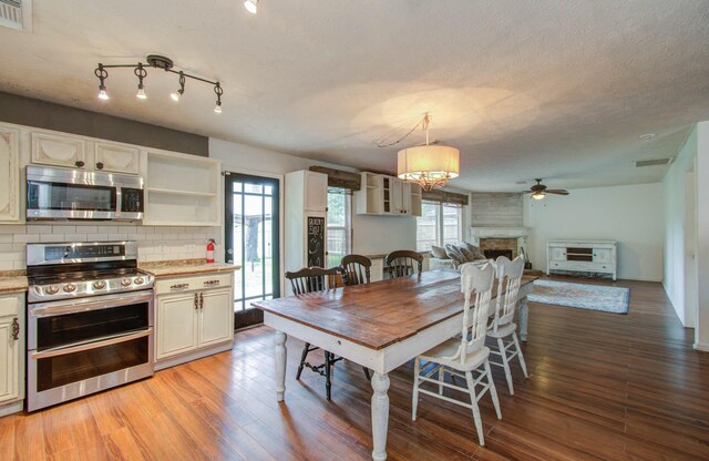 dining room with a textured ceiling, light hardwood / wood-style flooring, plenty of natural light, and ceiling fan