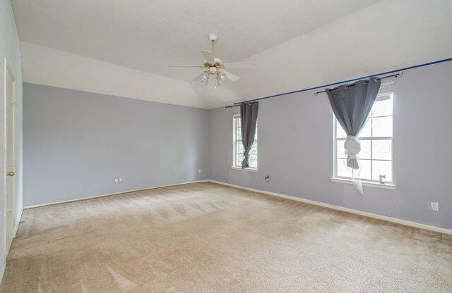 unfurnished room with ceiling fan, light colored carpet, and vaulted ceiling