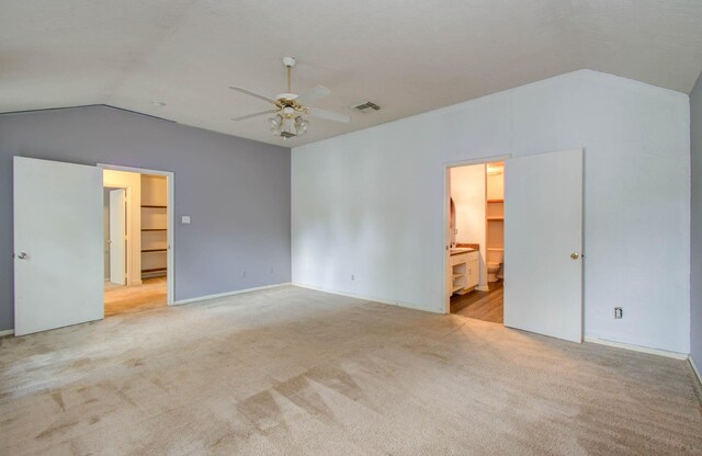 carpeted spare room with ceiling fan and vaulted ceiling