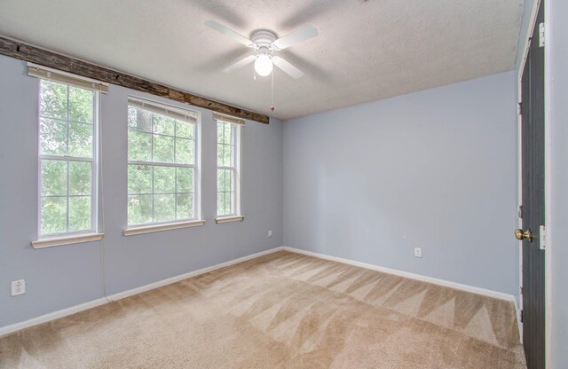 unfurnished room featuring a textured ceiling, light colored carpet, and ceiling fan