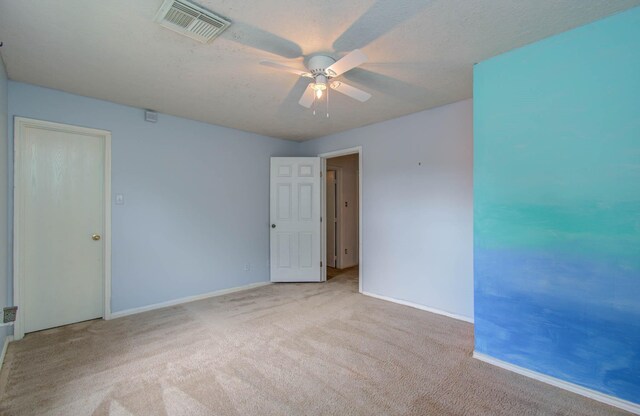 carpeted empty room with a textured ceiling and ceiling fan