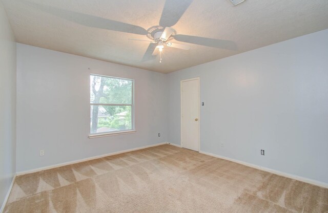 unfurnished room featuring ceiling fan, light colored carpet, and a textured ceiling