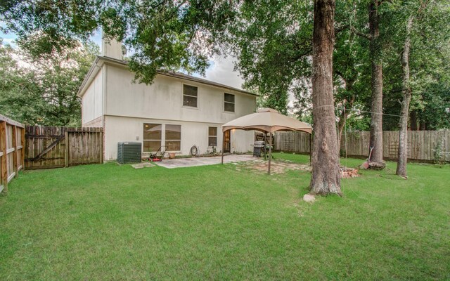 back of house with a gazebo, cooling unit, and a lawn