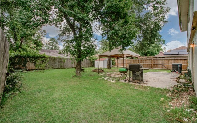 view of yard with a patio area, a storage shed, and central AC