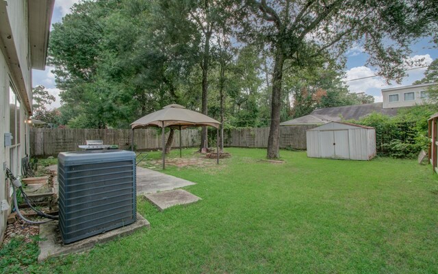 view of yard featuring a gazebo, a storage shed, and central air condition unit