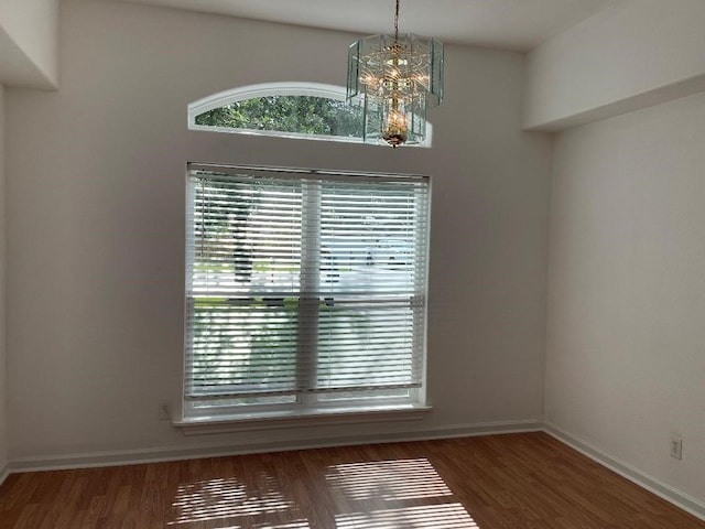 empty room featuring dark hardwood / wood-style floors and a chandelier