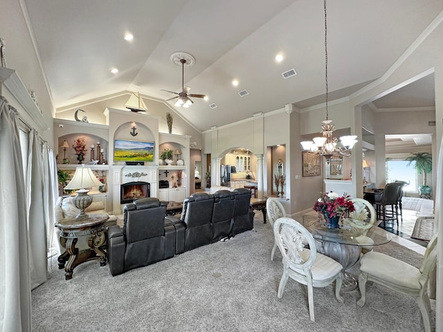 carpeted dining area with ornamental molding, ceiling fan with notable chandelier, and high vaulted ceiling