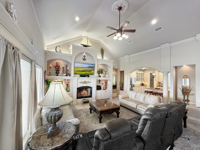 living room with crown molding, decorative columns, ceiling fan, a fireplace, and carpet