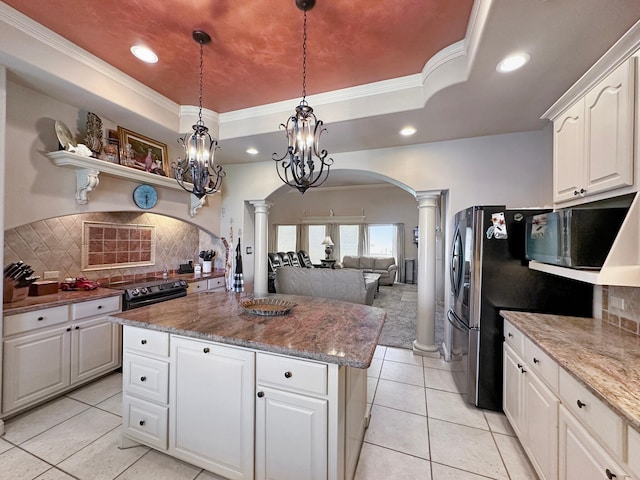 kitchen with ornate columns, white cabinetry, a raised ceiling, and backsplash