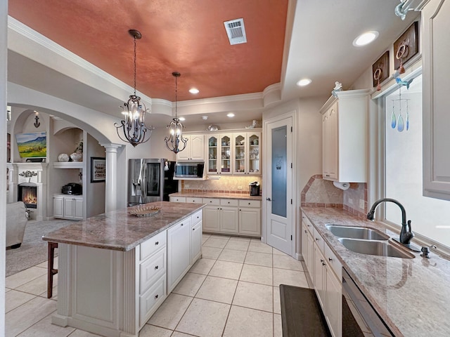 kitchen featuring a kitchen island, decorative backsplash, stainless steel appliances, and white cabinets