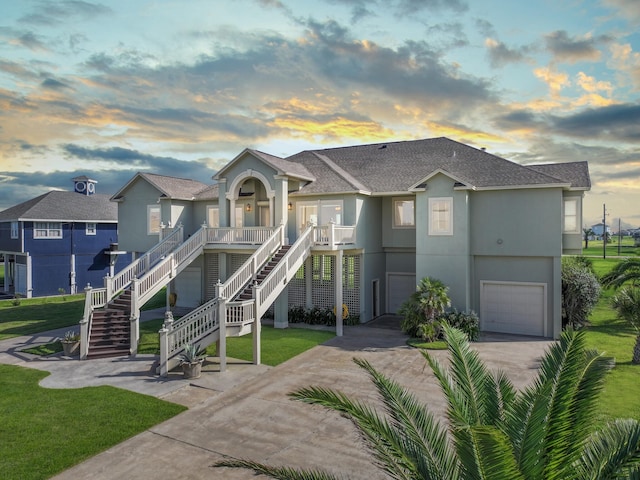 multi unit property with a porch, a garage, and a lawn