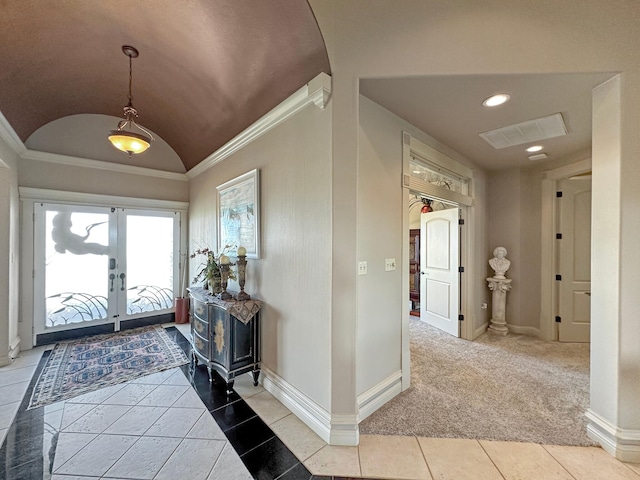 foyer featuring vaulted ceiling, french doors, light tile patterned floors, and ornamental molding