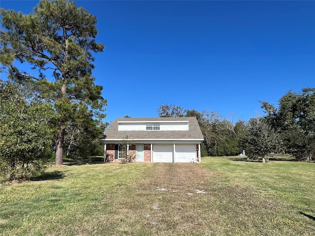 rear view of property with a lawn and a garage