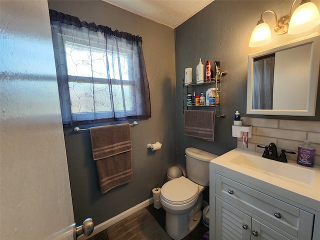 bathroom with decorative backsplash, hardwood / wood-style flooring, toilet, and vanity