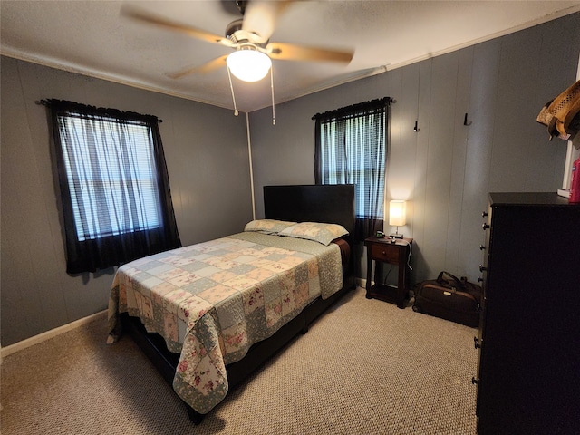 carpeted bedroom with ornamental molding and ceiling fan