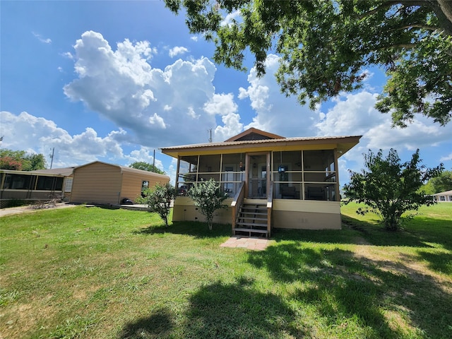 back of house with a sunroom and a lawn