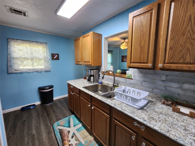 kitchen featuring light stone countertops, dark hardwood / wood-style flooring, sink, and ceiling fan