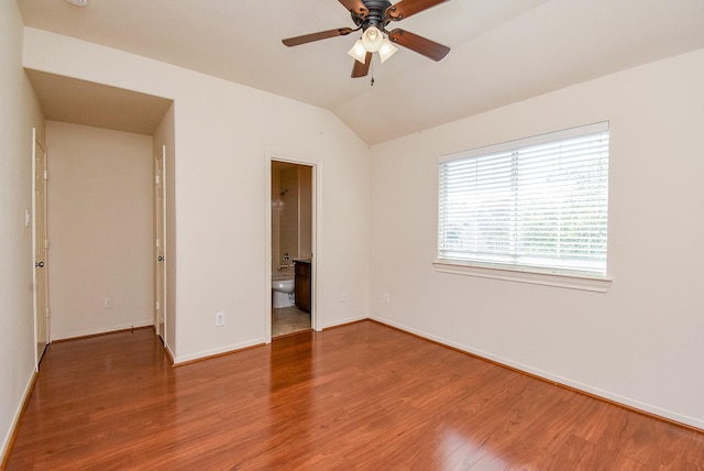 unfurnished bedroom with hardwood / wood-style flooring, lofted ceiling, and ensuite bath