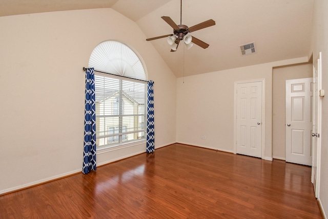 spare room featuring dark wood-type flooring, ceiling fan, and vaulted ceiling