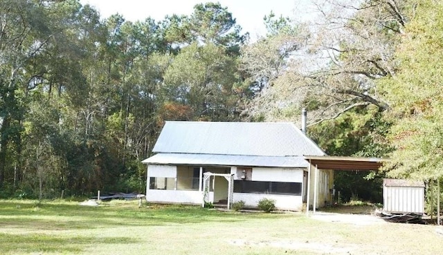 view of front of house with a carport and a front lawn