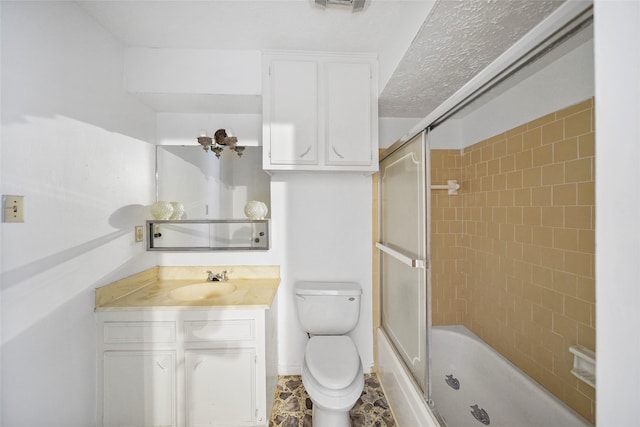 full bathroom featuring toilet, vanity, bath / shower combo with glass door, and a textured ceiling